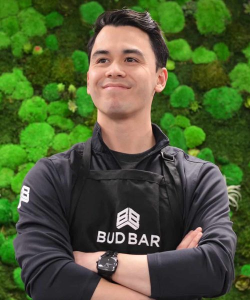 budbar-employee-posing-on-green-wall